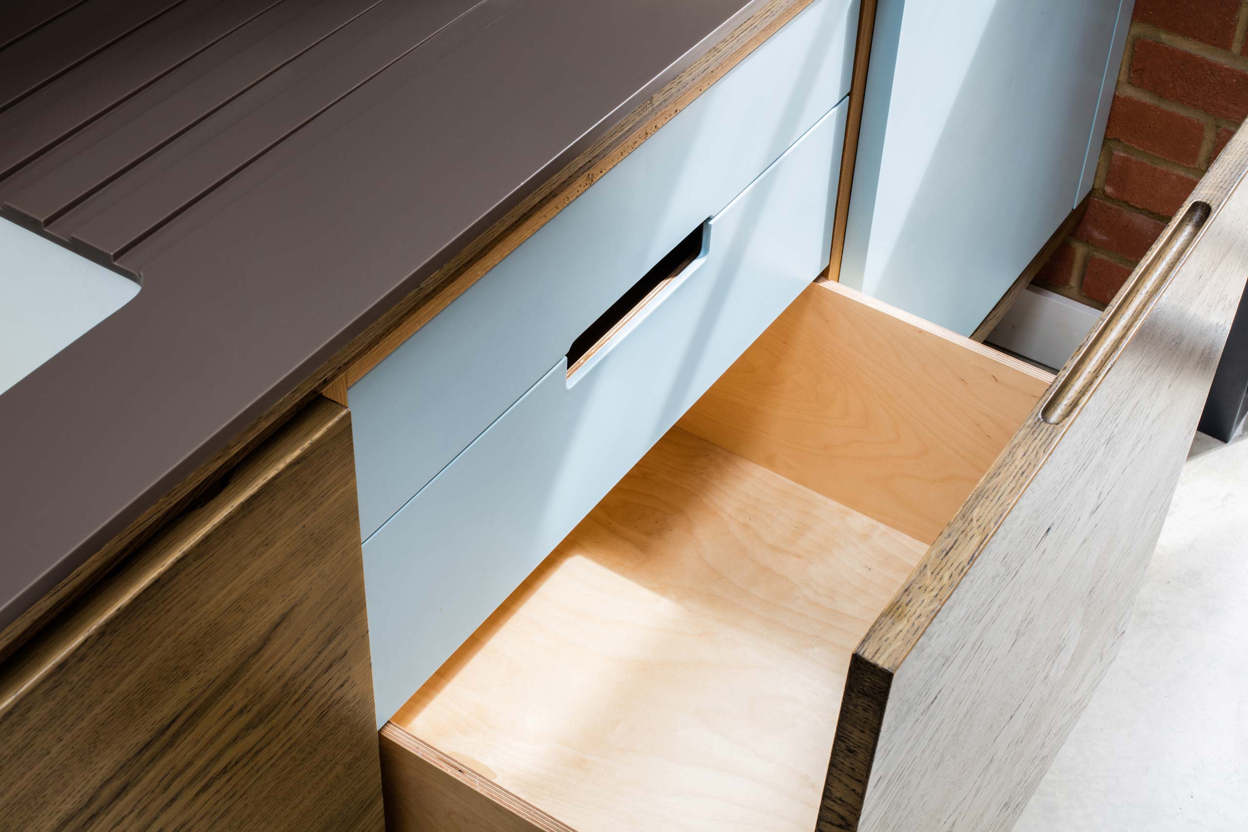 Bespoke fumed oak and corian kitchen with birch ply drawer interiors